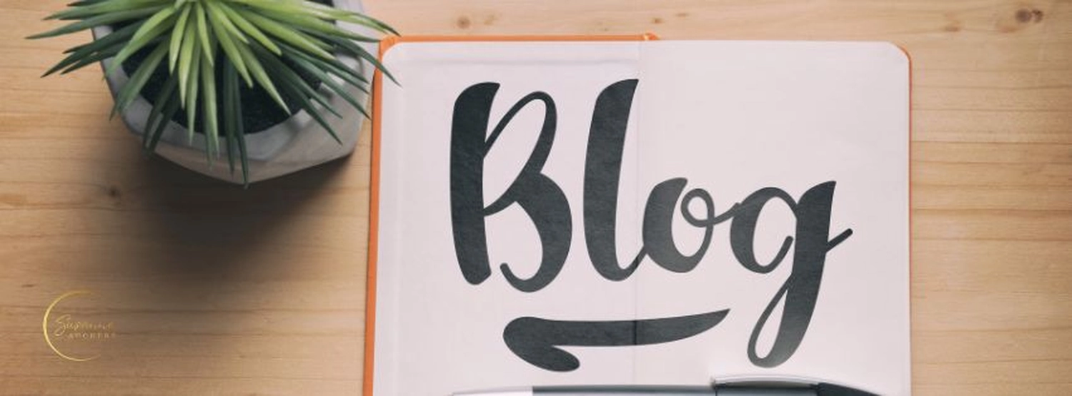 stress.coaching - Hypnose, Coaching, Seminare - Ein aufgeschlagenes Notizbuch mit dem Wort „Blog“ in großen, schwarzen Buchstaben. Auf einem Holzschreibtisch stehen außerdem eine kleine Topfpflanze und ein Stift.